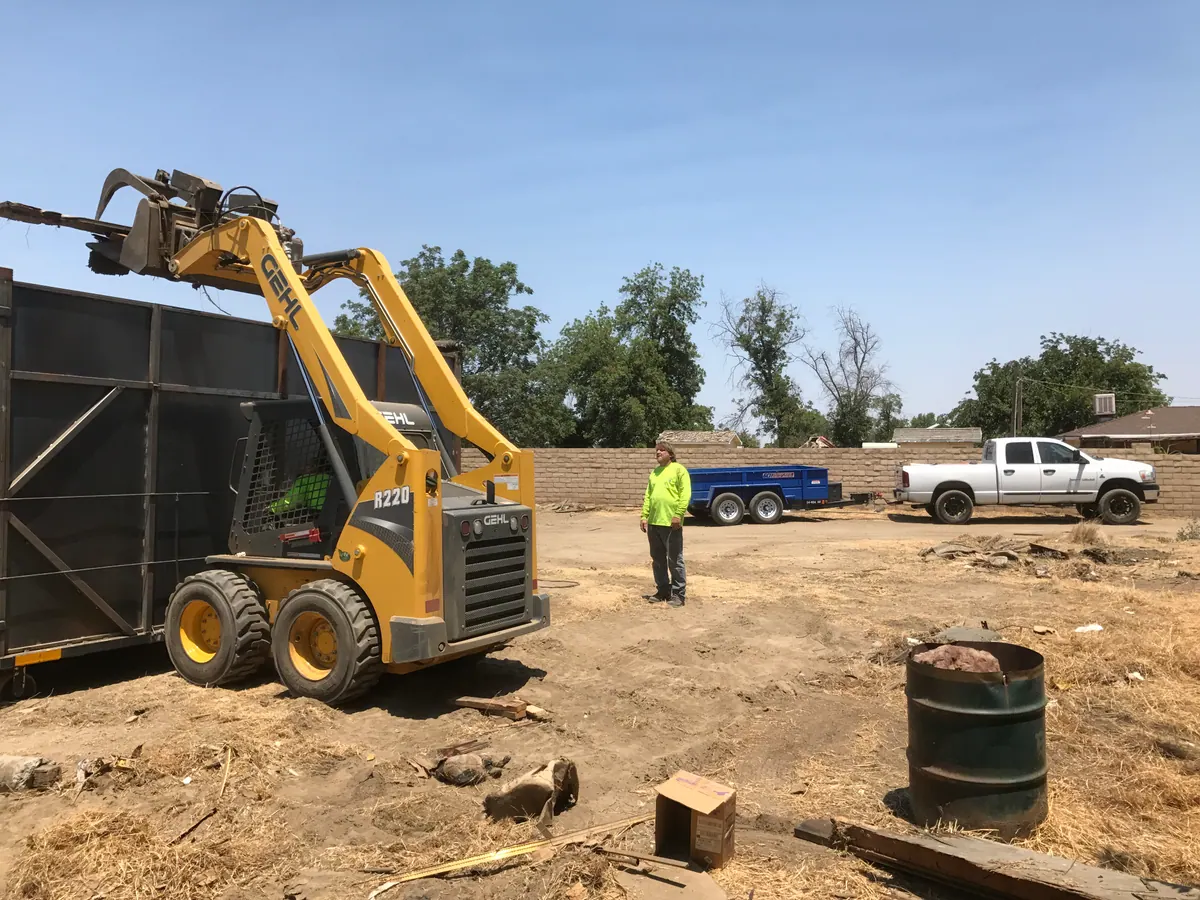 An ACH Services crew and skid steer working a commercial site in Bakersfield